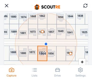SCOUTRE parcel picker: house numbers drawn on every building, a blue GPS dot on the street, and the parcel in front of the phone outlined in orange.